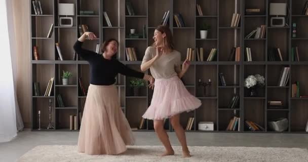 Frau ihre ältere Mutter trägt flauschige Röcke tanzen zu Hause — Stockvideo