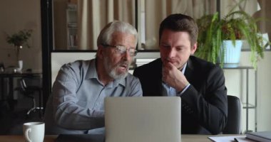 Genç meslektaşımla birlikte projeye odaklanmış orta yaşlı çalışanım..