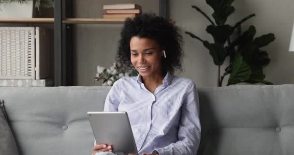 Afrikaanse vrouw praten met familie op afstand met behulp van tablet en videoconferentie — Stockvideo