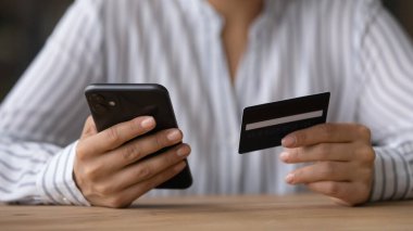Çevrimiçi kredi kartıyla ödeme yapan kadını kapat, akıllı telefon kullanarak.
