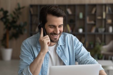 Gülümseyen iş adamını kapat. Telefonda konuş ve dizüstü bilgisayar kullan.