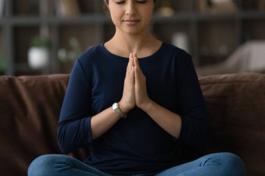 Huzurlu Hintli kadın meditasyon yapıyor, kanepede oturuyor.