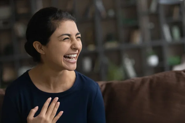 Close up overjoyed Indian woman laughing, sitting on couch — Stock Photo, Image