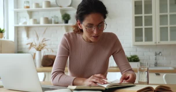 Mujer leyendo libro de texto tomando notas estudiando en casa — Vídeos de Stock
