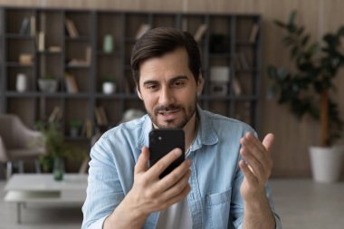 Kendine güvenen iş adamı video görüşmesi yapıyor, akıllı telefon tutuyor, internette sohbet ediyor.