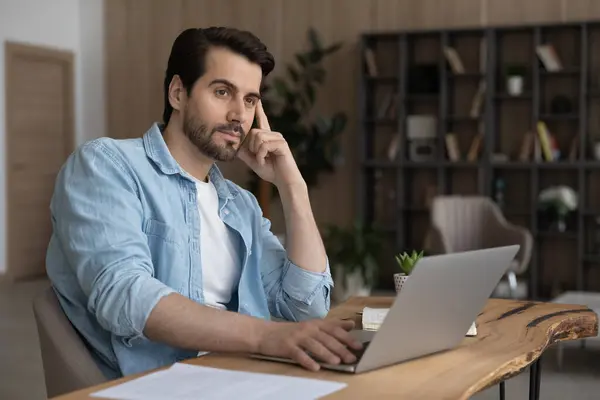 Empresário pensativo olhando para o lado, ponderando estratégia, trabalhando no laptop — Fotografia de Stock