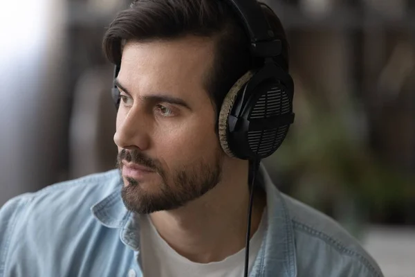 Close up dreamy man in headphones looking to aside — Stock Photo, Image