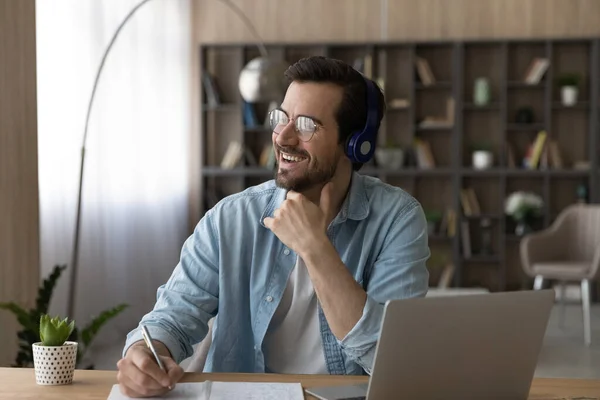 Dreamy man in headphones and glasses distracted from online studying — Stock Photo, Image