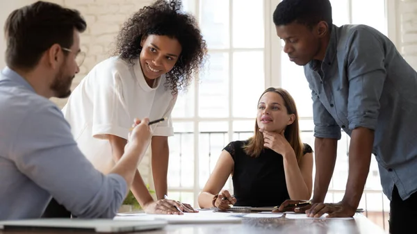 Happy multiracial colleagues discussing project strategy in office. — Stock Photo, Image