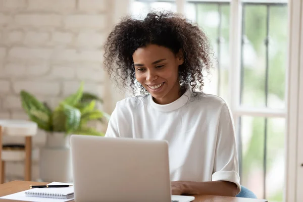 Feliz millennial afroamericana mujer de negocios que trabaja en la computadora. — Foto de Stock