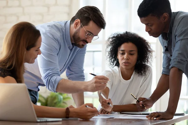 Geconcentreerde jonge collega 's van gemengde rassen discussiëren over onderzoeksresultaten. — Stockfoto