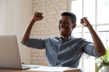 Aşırı neşeli genç Afrikalı Amerikalı adam online başarısını kutluyor..