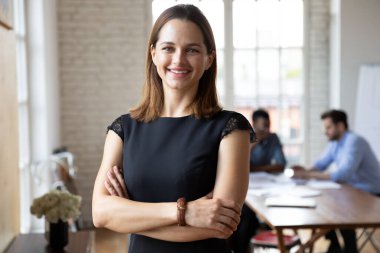 Kendine güvenen gülümseyen çekici bayan takım liderinin portresi..