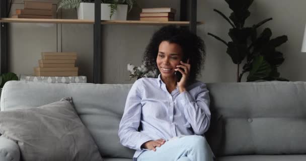Приваблива усмішка африканська жінка розмовляє по телефону. — стокове відео