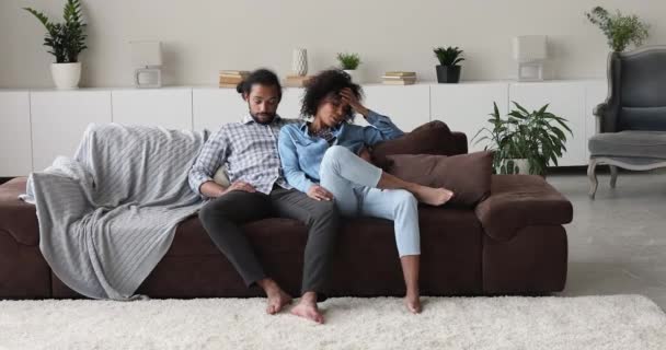 Африканская пара сидит на диване, чувствуя усталость, испытывая жизненные проблемы — стоковое видео