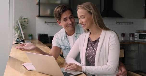 Couple sit at table use laptop discuss purchase on internet — Stock Video