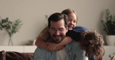 Neşeli küçük kardeşler samimi gülen babaları gıdıklıyor..
