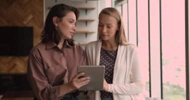 Sosyal medya stratejisi üzerinde çalışan iki işkadını dijital tablet kullanıyor