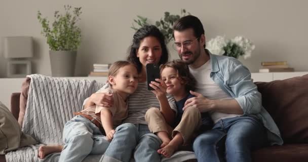 Happy bonding oprechte familie met behulp van smartphone apps. — Stockvideo