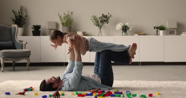 Cuidando forte jovem pai levantando no ar pequena filha bonito. — Vídeo de Stock