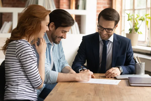 Happy Millennial Pasangan menandatangani kontrak dengan manajer pada pertemuan — Stok Foto