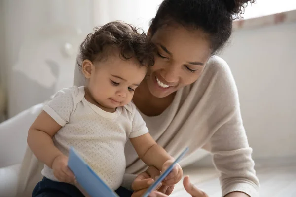 Feliz africano americano mamá leer libro a bebé hija — Foto de Stock