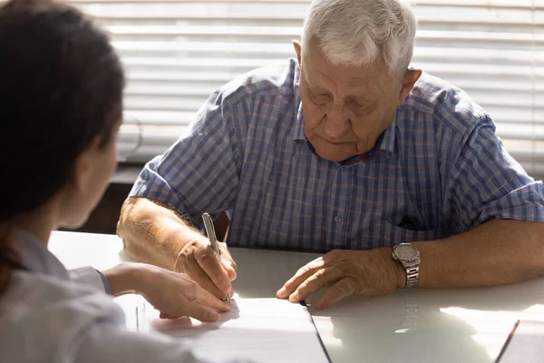 Hombre jubilado firma contrato de servicio de salud en consultorio médico — Foto de Stock