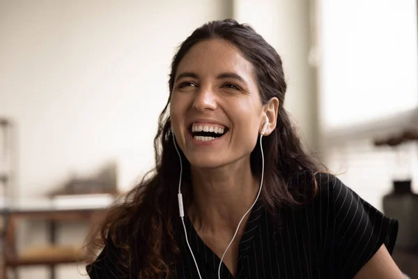 Fejlövés a túlfűtött nevető millenniumi latin nő visel vezetékes fülhallgató — Stock Fotó
