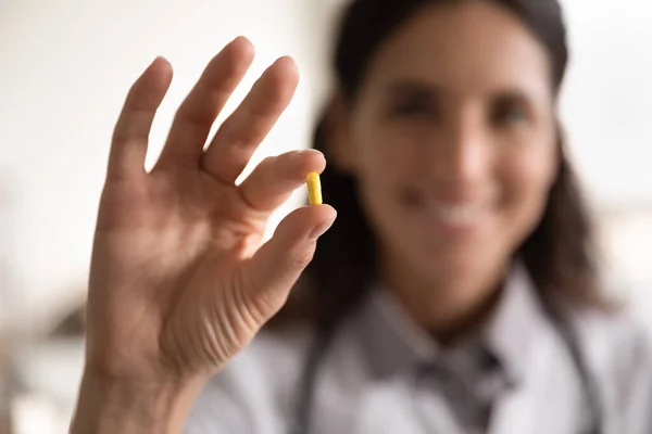 Glimlachende vrouwelijke apotheker op zoek naar camera presenteren nieuwe effectieve pil — Stockfoto