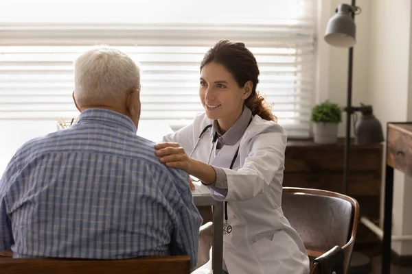 Sorridente medico femminile toccare anziano spalla maschile rassicurare dare speranza — Foto Stock