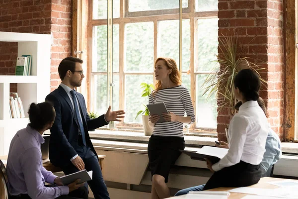 Diversos empleados colegas discutiendo el proyecto en la sesión informativa, de pie en círculo — Foto de Stock