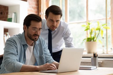 Dizüstü bilgisayarda birlikte çalışan iki iş arkadaşı.