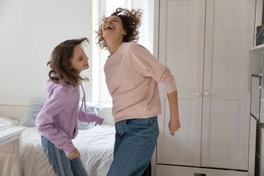 Mutlu anne, neşeli genç kızla dans ediyor..