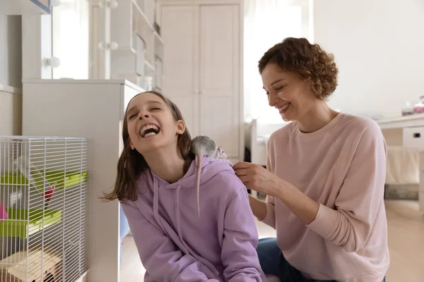 Överlycklig tonåring flicka njuter av lekstund med mamma och husdjur. — Stockfoto