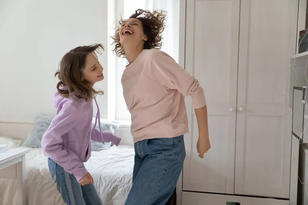 Lycklig mor dansar med glad tonåring dotter. — Stockfoto