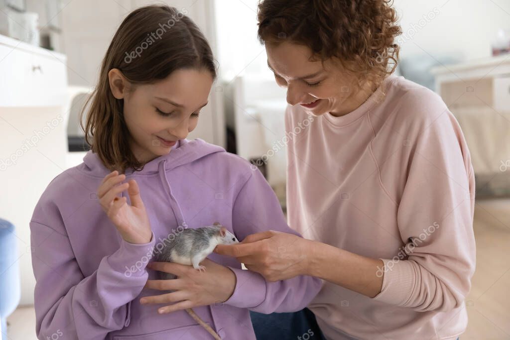 Young pretty teen kid girl playing with animal with mum.