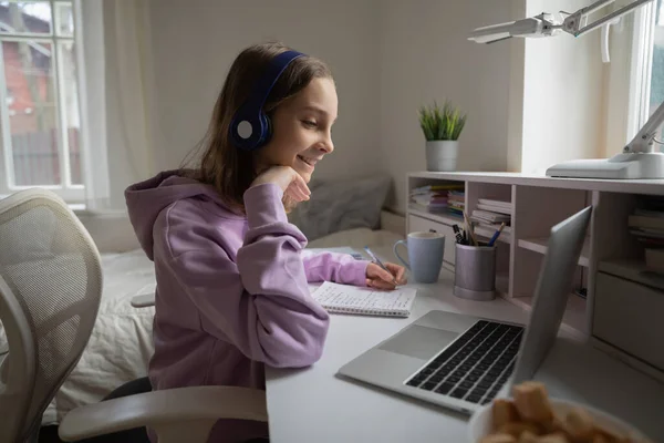 Smiling teenage schoolgirl watching educational lecture at home. — Stock Photo, Image