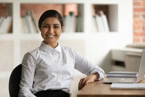 Head shot portrait smiling Indian businesswoman sitting at work desk — Stock Photo, Image