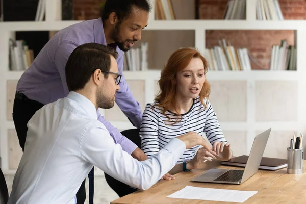 Three diverse colleagues working on project together, using laptop — Stock Photo, Image