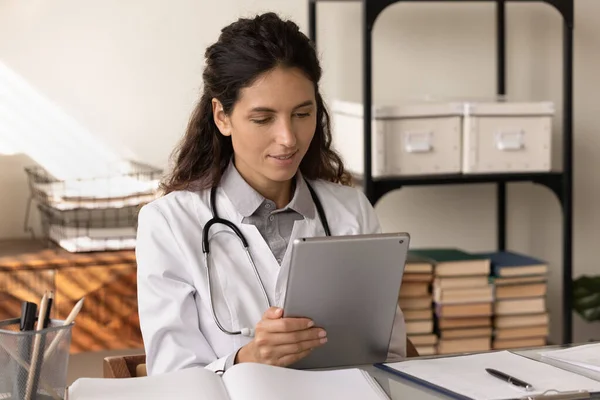 Trabajadora médica joven usa la información del estudio de almohadillas en el sitio web —  Fotos de Stock