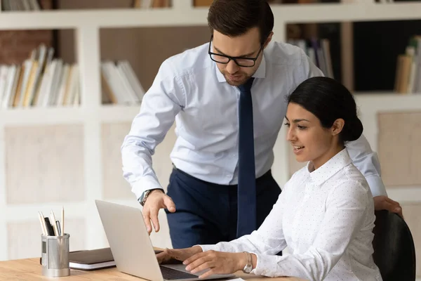 Mentor zakenman opleiding Indiase zakenvrouw stagiaire, wijzend op laptop scherm — Stockfoto