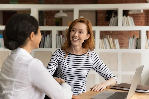 Twee gelukkige diverse zakenvrouwen schudden elkaar de hand bij een ontmoeting in het kantoor — Stockfoto