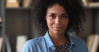 Güzel Afrikalı kadın kameraya bakıp gülümsüyor.