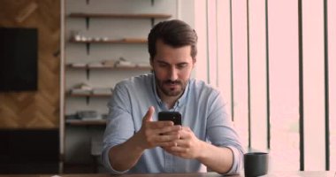 İş adamı elinde akıllı telefon ile iyi haberlerle mesaj okuyor.