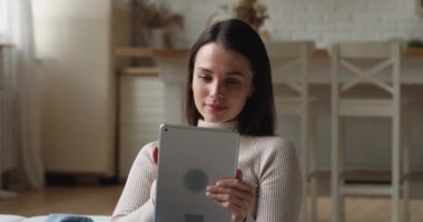 Güzel bir milenyum kadını elinde tabletle inanılmaz yeni bir şey okurken mutlu hissediyor.