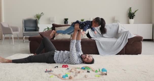 Papa africain couché sur le plancher ascenseur sur les bras fille mignonne — Video