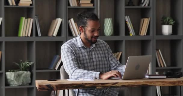 Afrikaanse werknemer zitten aan bureau doen werk met behulp van computer — Stockvideo