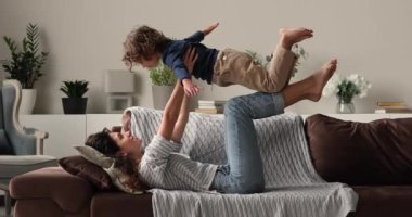 Küçük çocukla oynayan mutlu genç bir kadın..