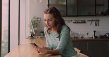 Akıllı telefondaki mesajları okuyan kadın iyi haberlerle mutlu oluyor.