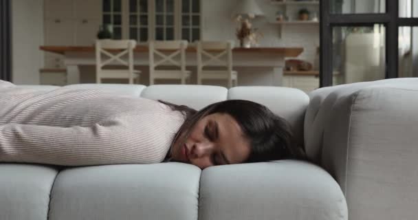 Cansado jovem mulher caindo no sofá em casa — Vídeo de Stock
